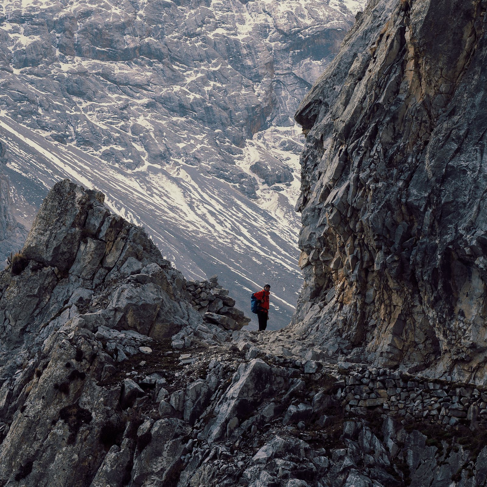 Climber against rocky scree with brand-mark sun